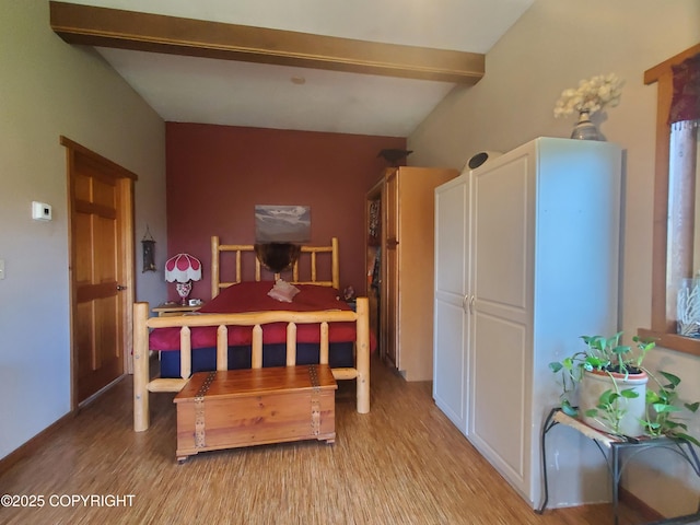 bedroom featuring light wood-type flooring and beam ceiling