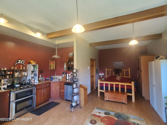 kitchen with light wood finished floors, dishwasher, a sink, brown cabinets, and hanging light fixtures