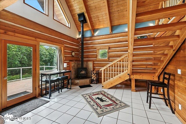 4510 Thomas Ct, Homer, AK 99603 - living area featuring a wood stove, log walls, stairway, light tile patterned flooring, and a high ceiling