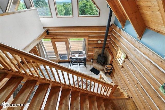 4510 Thomas Ct, Homer, AK 99603 - stairs with plenty of natural light, a wood stove, rustic walls, and a towering ceiling