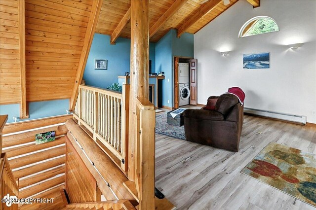 4510 Thomas Ct, Homer, AK 99603 - corridor featuring a baseboard heating unit, stacked washer / drying machine, a wood ceiling with exposed beams, wood finished floors, and rustic walls