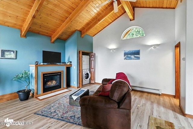 4510 Thomas Ct, Homer, AK 99603 - living area with stacked washing machine and dryer, a baseboard radiator, wood finished floors, a wood ceiling with exposed beams, and high vaulted ceiling