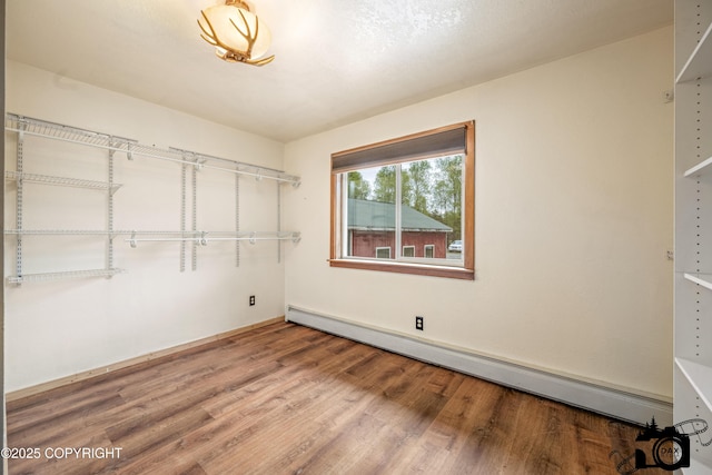 4800 W Lucy Lake Rd, Wasilla, AK 99623 - walk in closet featuring a baseboard radiator and wood finished floors