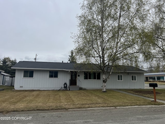 single story home with a front lawn and board and batten siding