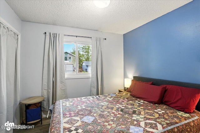 bedroom featuring a textured ceiling and wood finished floors