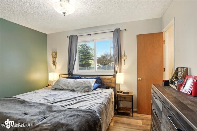 bedroom with light wood-style flooring and a textured ceiling