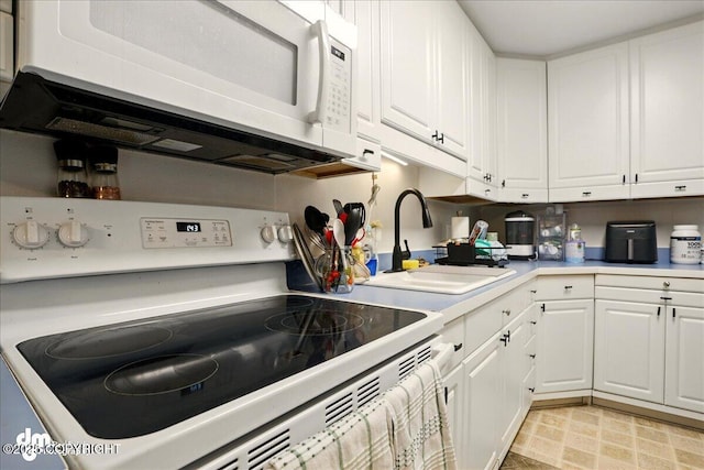 kitchen featuring white appliances, a sink, white cabinets, and light countertops