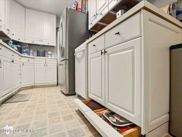 kitchen featuring white cabinetry and freestanding refrigerator