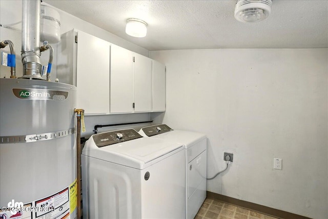laundry area with water heater, cabinet space, washer and clothes dryer, baseboards, and a textured ceiling