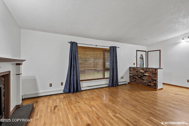 unfurnished living room with wood finished floors, baseboard heating, a textured ceiling, and a fireplace
