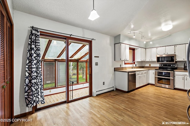 kitchen with stainless steel appliances, a baseboard heating unit, a sink, light wood-style flooring, and white cabinets