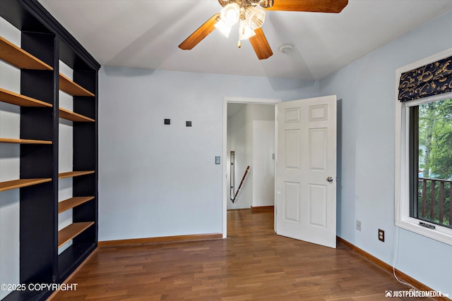 unfurnished bedroom with dark wood-style flooring, baseboards, and ceiling fan