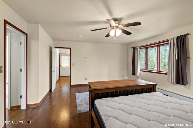 bedroom featuring baseboards, wood finished floors, a baseboard radiator, and ceiling fan