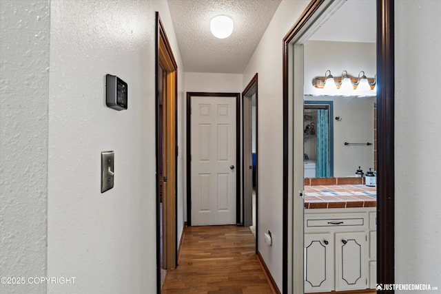 hall featuring wood finished floors and a textured ceiling