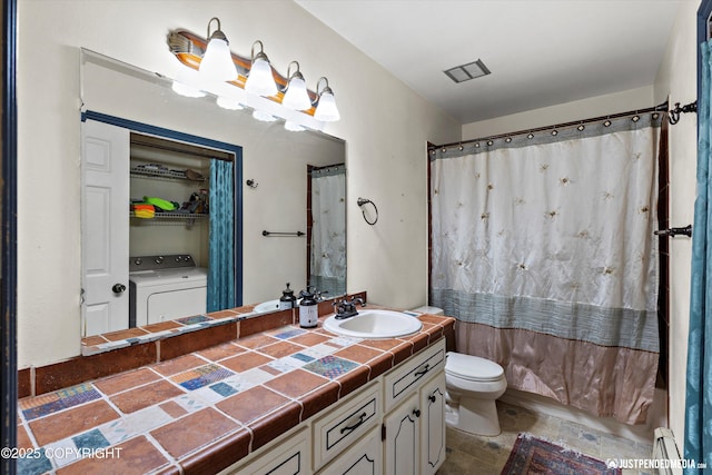 full bathroom featuring washer / dryer, toilet, vanity, baseboard heating, and a shower with curtain