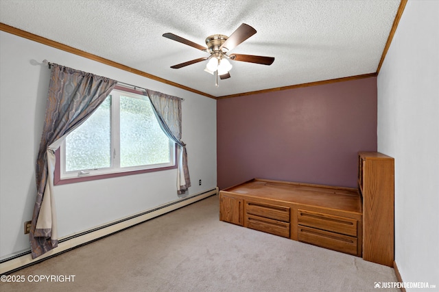 unfurnished bedroom featuring baseboard heating, carpet floors, ornamental molding, a textured ceiling, and a ceiling fan