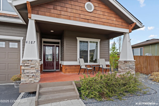 4187 Chiniak Bay Dr, Anchorage, AK 99515 - doorway to property featuring a porch, a garage, and fence