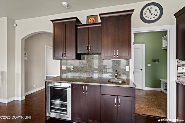 4187 Chiniak Bay Dr, Anchorage, AK 99515 - kitchen with beverage cooler, decorative backsplash, dark stone countertops, arched walkways, and a sink