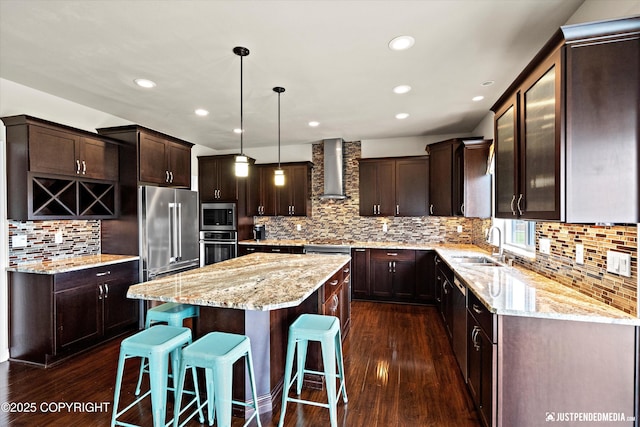4187 Chiniak Bay Dr, Anchorage, AK 99515 - kitchen featuring appliances with stainless steel finishes, a kitchen island, dark brown cabinets, backsplash, and a sink