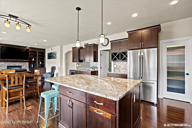 4187 Chiniak Bay Dr, Anchorage, AK 99515 - kitchen with high end fridge, dark wood-type flooring, light stone counters, a kitchen island, and recessed lighting