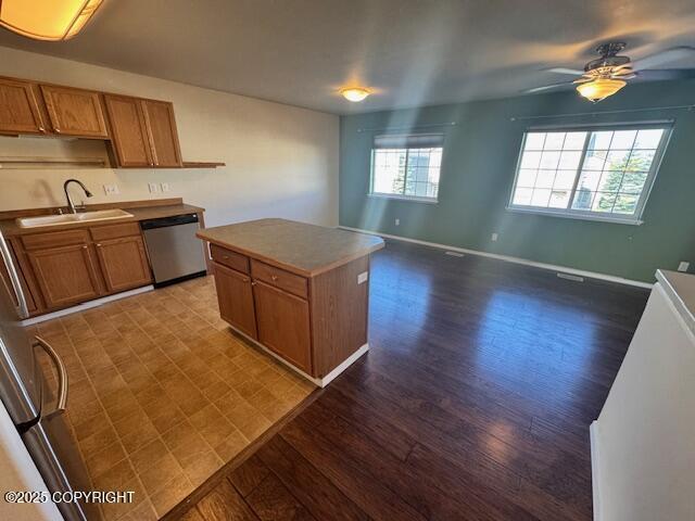 kitchen featuring dishwasher, a sink, dark wood-type flooring, and ceiling fan