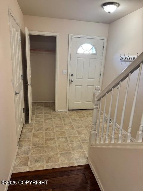 foyer entrance featuring stairs and baseboards