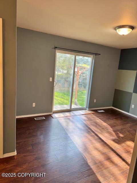 unfurnished room with baseboards and wood finished floors