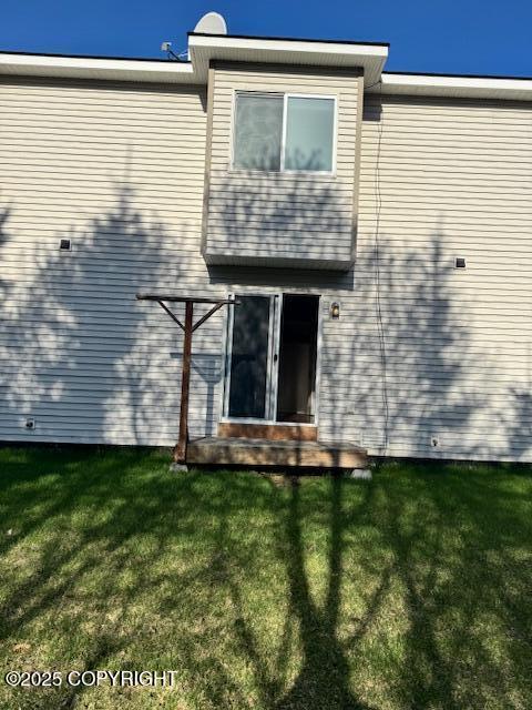 rear view of property with a lawn