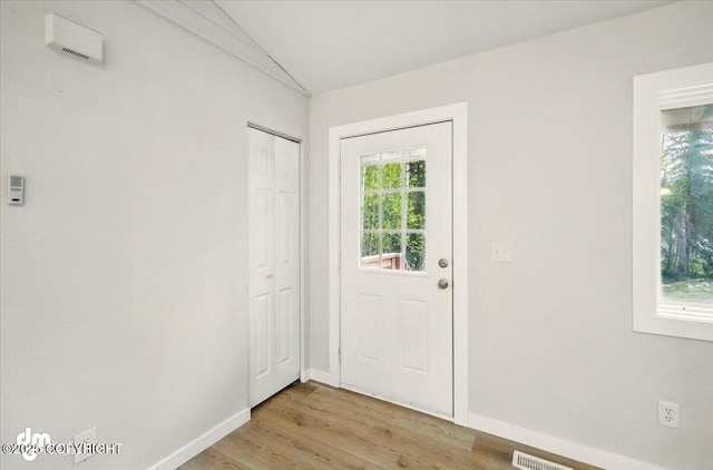 2411 N Friar Tuck Ct, Big Lake, AK 99623 - doorway to outside featuring light wood-style floors, baseboards, and vaulted ceiling