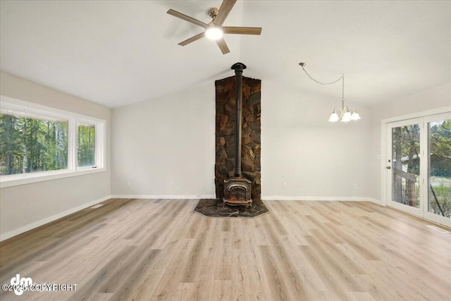 2411 N Friar Tuck Ct, Big Lake, AK 99623 - unfurnished living room with a wood stove, wood finished floors, ceiling fan, baseboards, and lofted ceiling