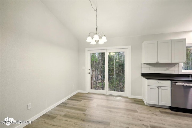 2411 N Friar Tuck Ct, Big Lake, AK 99623 - unfurnished dining area with healthy amount of natural light, a chandelier, baseboards, light wood-style flooring, and lofted ceiling