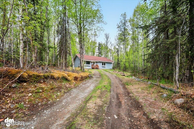 2411 N Friar Tuck Ct, Big Lake, AK 99623 - ranch-style house with dirt driveway and a forest view
