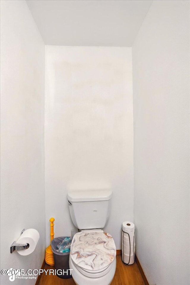 bathroom with wood finished floors, toilet, and baseboards