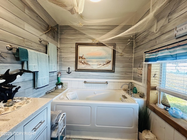 bathroom with wooden walls, a garden tub, and vanity