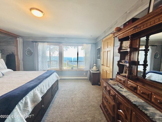 bedroom featuring dark colored carpet, a baseboard heating unit, and baseboards