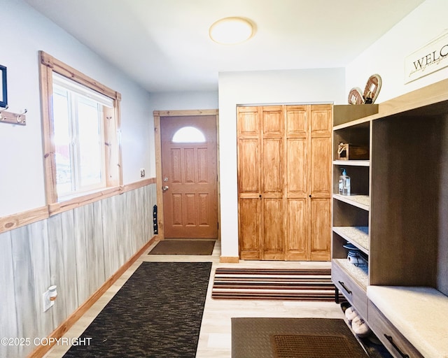 entryway featuring a wainscoted wall, wood finished floors, and wooden walls