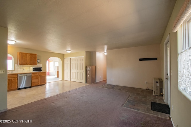 255 Lee Dr, Homer, AK 99603 - kitchen with dishwasher, white microwave, arched walkways, light countertops, and backsplash