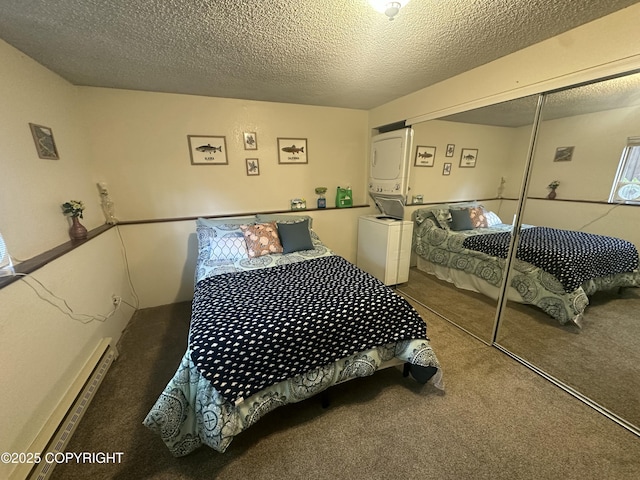 bedroom featuring stacked washer and clothes dryer, carpet, a closet, a textured ceiling, and a baseboard heating unit