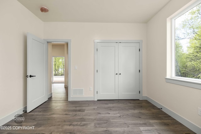 7254 E Riparian Loop, Palmer, AK 99645 - unfurnished bedroom with multiple windows, wood finished floors, and baseboards