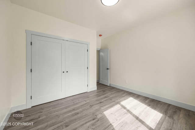 7254 E Riparian Loop, Palmer, AK 99645 - unfurnished bedroom featuring wood finished floors, baseboards, and a closet