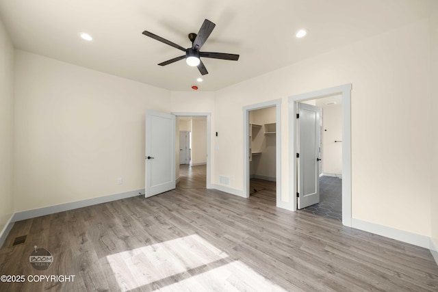 7254 E Riparian Loop, Palmer, AK 99645 - unfurnished bedroom with light wood-type flooring, a spacious closet, baseboards, recessed lighting, and a closet