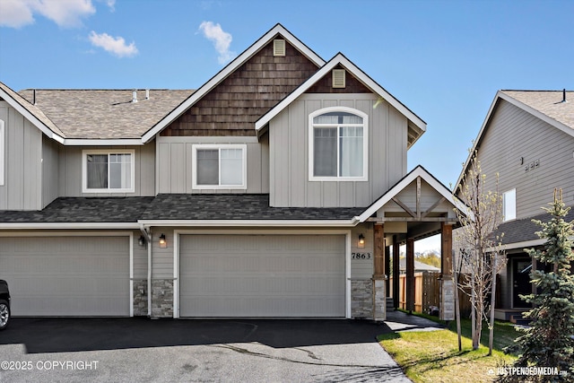 7863 Gate Creek Dr, Anchorage, AK 99502 - view of front facade featuring stone siding, asphalt driveway, board and batten siding, an attached garage, and roof with shingles