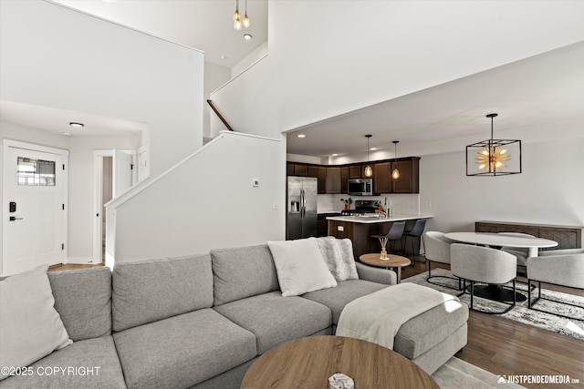 7863 Gate Creek Dr, Anchorage, AK 99502 - living room featuring wood finished floors, stairway, recessed lighting, a chandelier, and a high ceiling