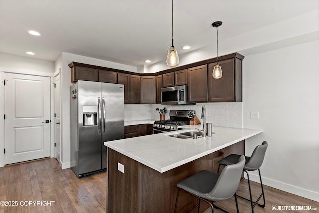 7863 Gate Creek Dr, Anchorage, AK 99502 - kitchen with stainless steel appliances, baseboards, dark brown cabinets, a peninsula, and light countertops