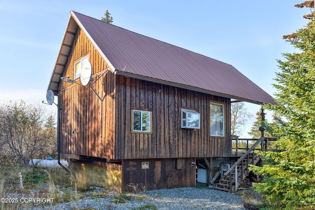 view of side of home with metal roof and stairs