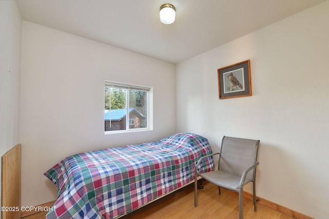 bedroom with wood finished floors and baseboards