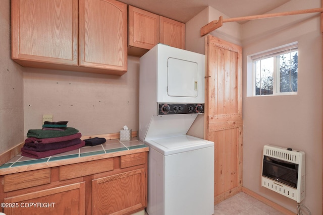 washroom with heating unit and stacked washer and clothes dryer