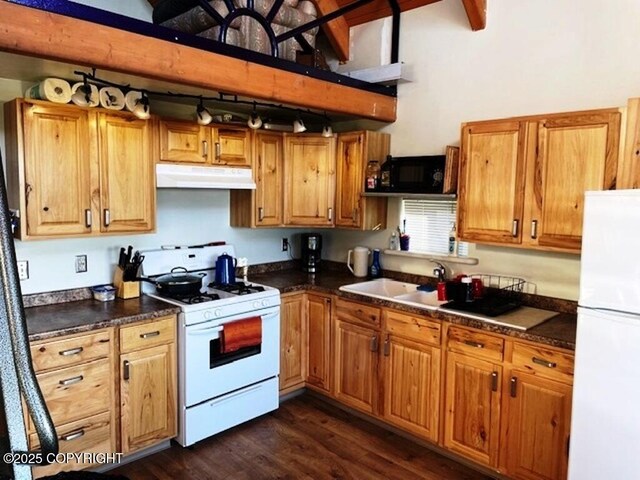 31580 Hannah Rene Rd, Anchor Point, AK 99556 - kitchen with white appliances, under cabinet range hood, dark countertops, and dark wood-type flooring