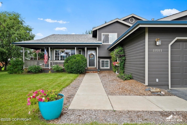 view of front of home featuring a front yard, an attached garage, and covered porch