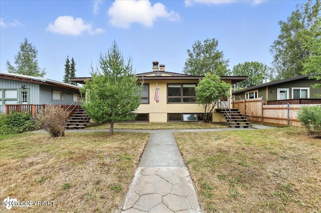 933 W 20th Ave, Anchorage, AK 99503 - view of front of home with stairway, a chimney, and a wooden deck